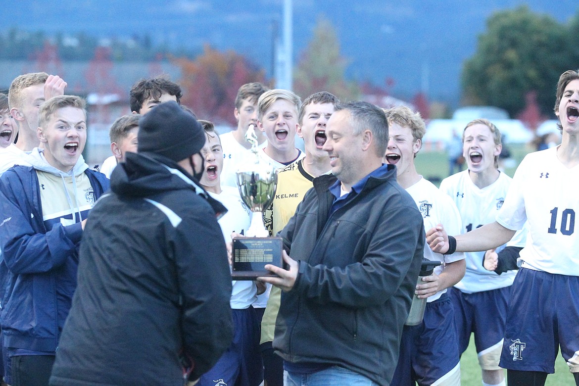 JASON ELLIOTT/Press
Aaron Lippy, Coeur d'Alene Charter Academy Athletic Director, presents first-year Timberlake boys soccer coach Justin Mooney with the 3A District 1-2 soccer championship trophy after the Tigers 1-0 win over the Panthers at The Fields at Real Life Ministries in Post Falls on Saturday.