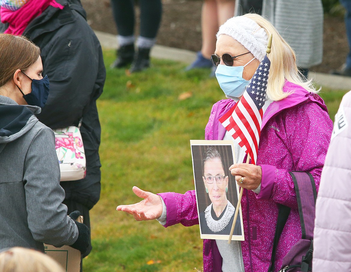 A woman who attended Saturday's rally and march at Riverstone Park holds a picture of Ruth Bader Ginsburg.