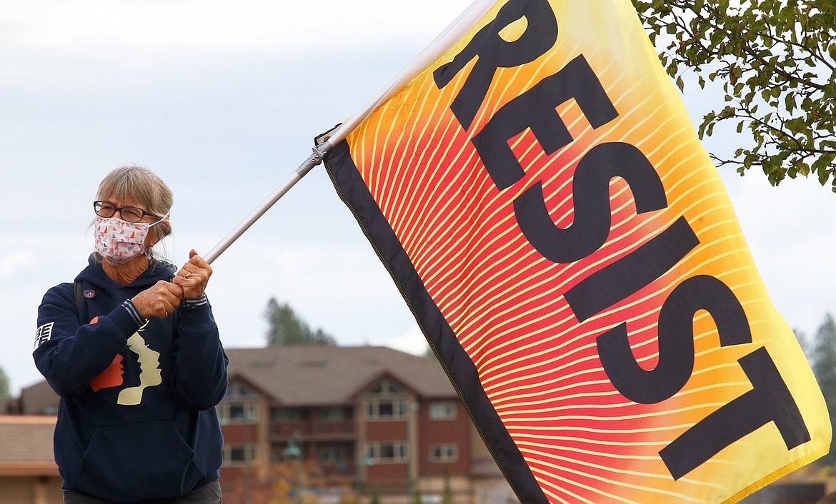 Rebecca Holland of Sandpoint holds a banner at the women's rally and march at Riverstone Park on Saturday.