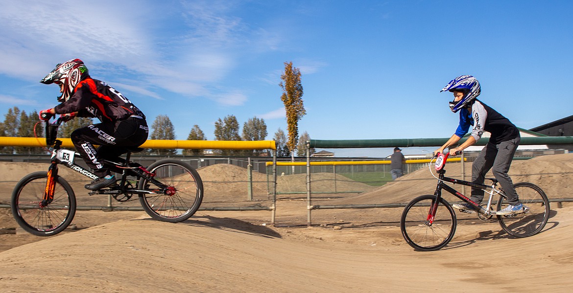 John Machado Jr., left, and Christian Brokke makes his way down the rhythm section at the BMX track in Moses Lake on Saturday, Oct. 17.