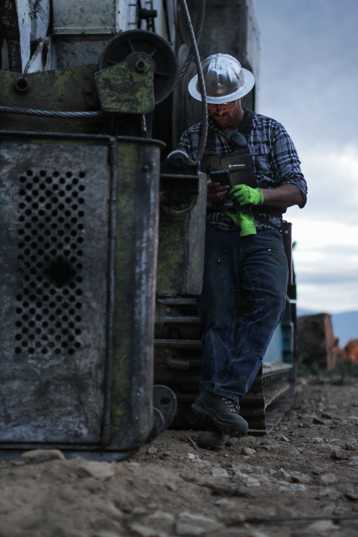 A logger for Dunkel Logging checks his phone  during a break on a recent job.