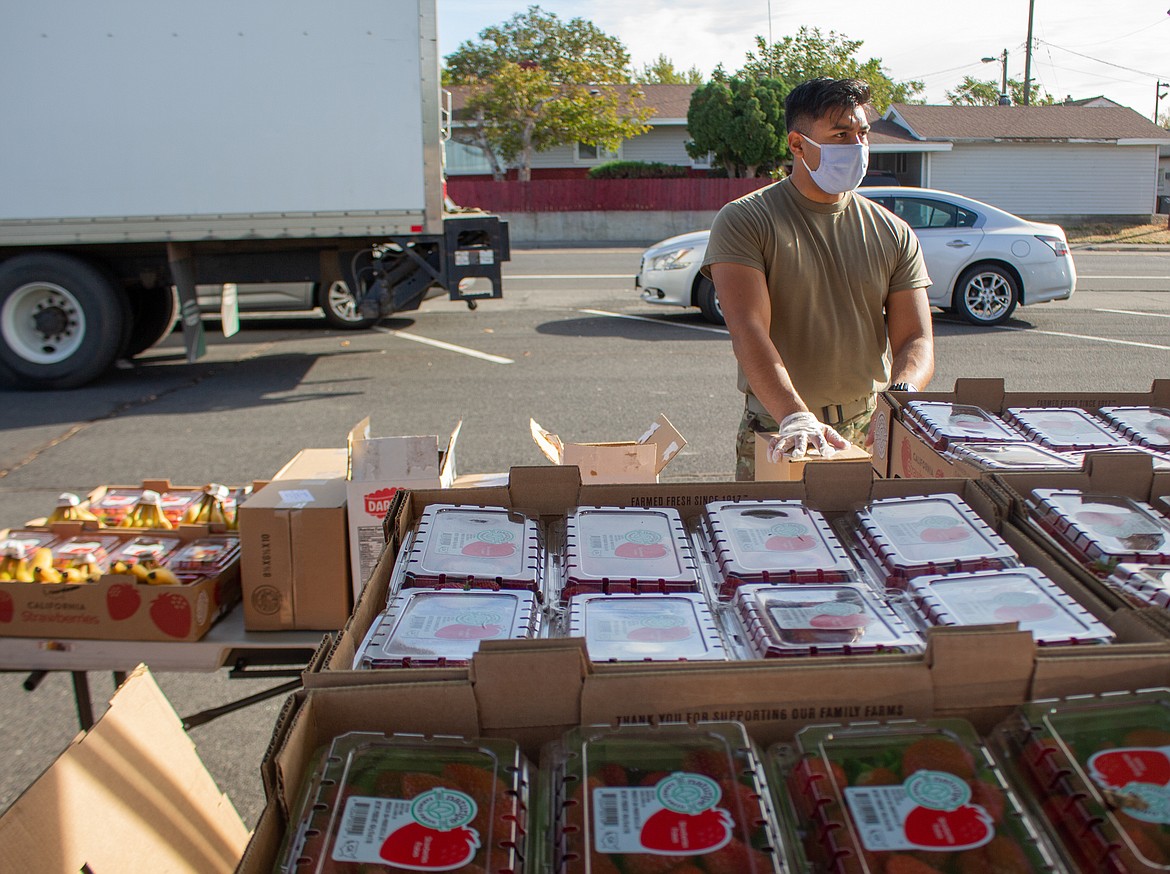 Washington Army National Guard Sgt. Emmanuel Torres, takes a momentary break between cars  at the Second Harvest Mobile Market food distribution in Othello on Tuesday.