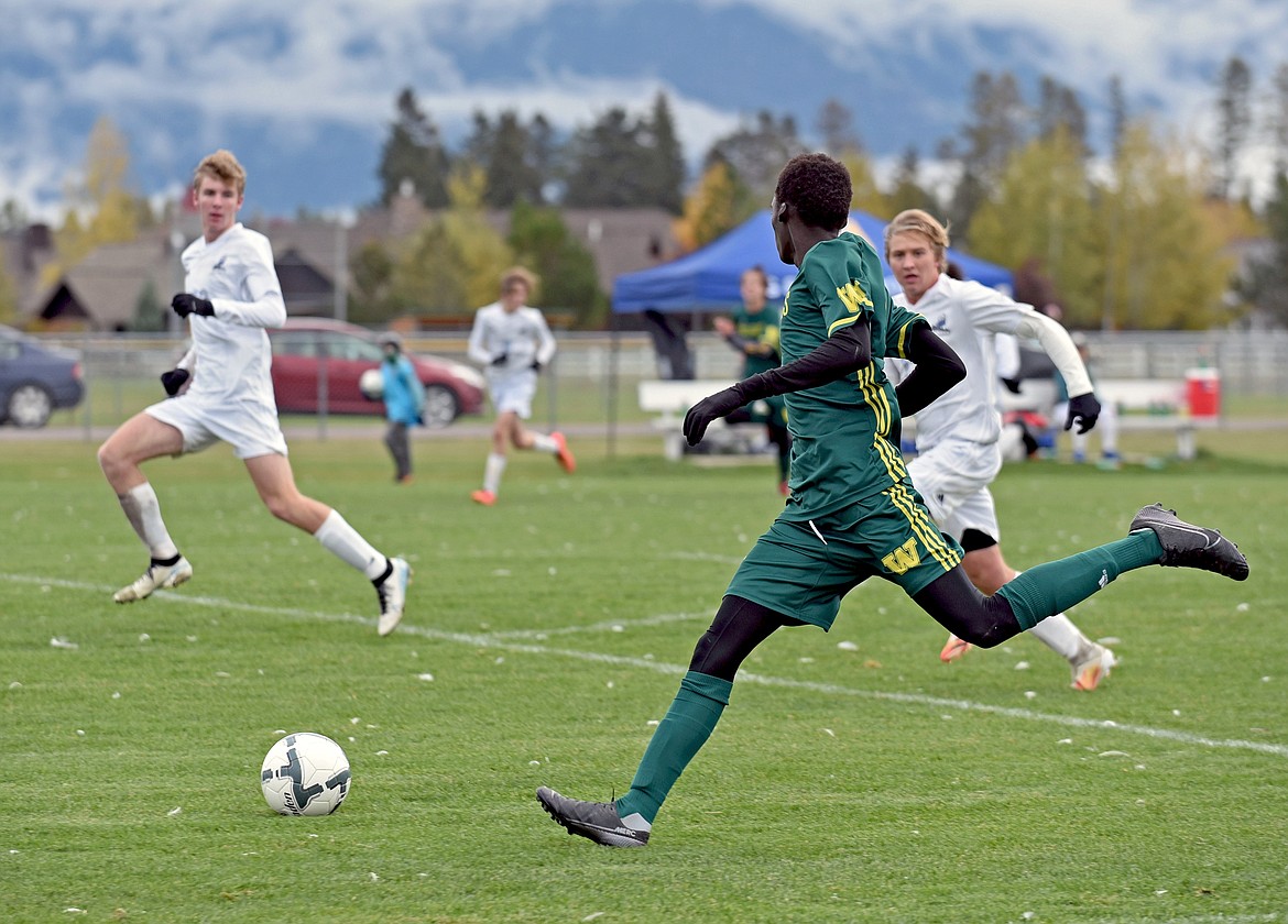 Bulldog senior Marvin Kimera sprints to catch up with a ball that broke through Lone Peak's defense in a quarterfinal playoff match Saturday morning at Smith Fields. (Whitney England/Whitefish Pilot)