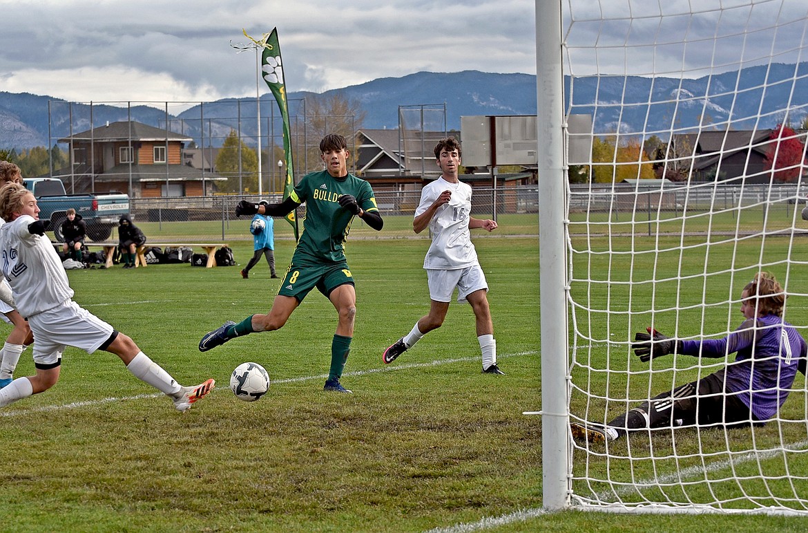 Whitefish senior Brandon Mendoza gets Lone Peak's defenders on their heels as he scores in the first half of a quarterfinal playoff match Saturday morning. (Whitney England/Whitefish Pilot)