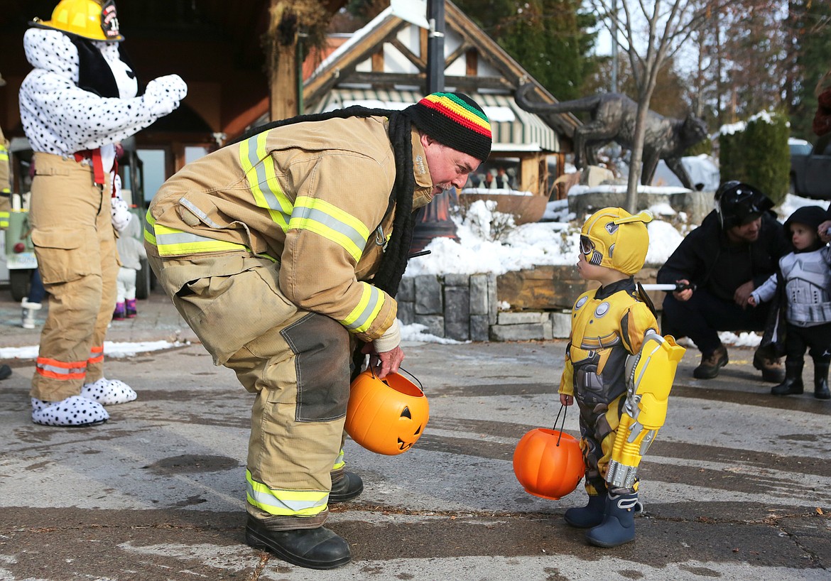 A firefighter greets a trick-or-treater during downtown trick-or-treating in Bigfork in 2019. 
Mackenzie Reiss