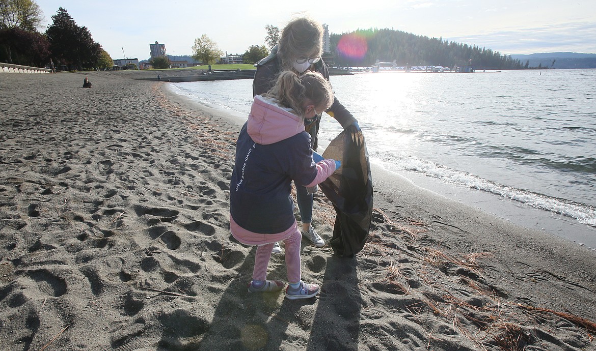 Hagadone Marine Group moorage manager Emily Arthurs and daughter Olivia Matthews, 8, pick up litter Tuesday on Coeur d'Alene City Beach. Hagadone Marine and Lake Coeur d'Alene Cruises employees spent the morning scouring the shoreline for garbage as part of the Water Sports Industry Association's Lake Cleanup Month.