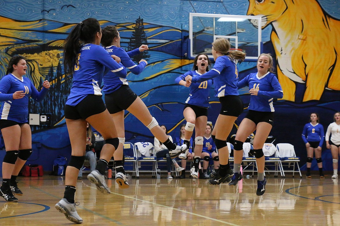 The Lady Cats celebrate after winning a point Tuesday night.