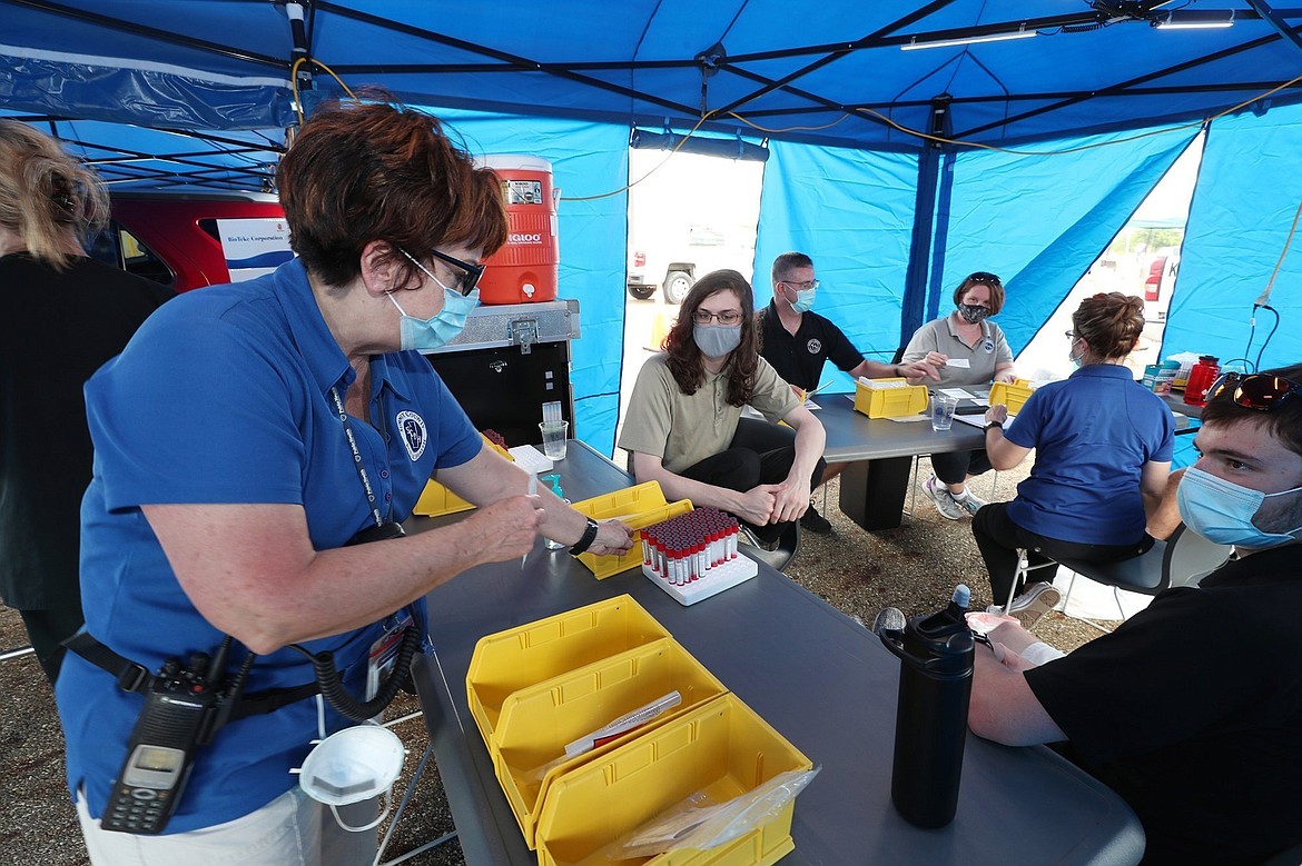 Health Commissioner at Summit County Department of Health Donna Skoda, left, explains the process of testing at a COVID-19 testing site at Chapel Hill Mall on Saturday, Sept. 12, 2020, in Akron, Ohio. Hospitals around the United States are starting to buckle from a resurgence of COVID-19 cases, with several states setting records for the number of people hospitalized and leaders scrambling to find extra beds and staff. New highs in cases have been reported in states big and small, from Idaho to Ohio.