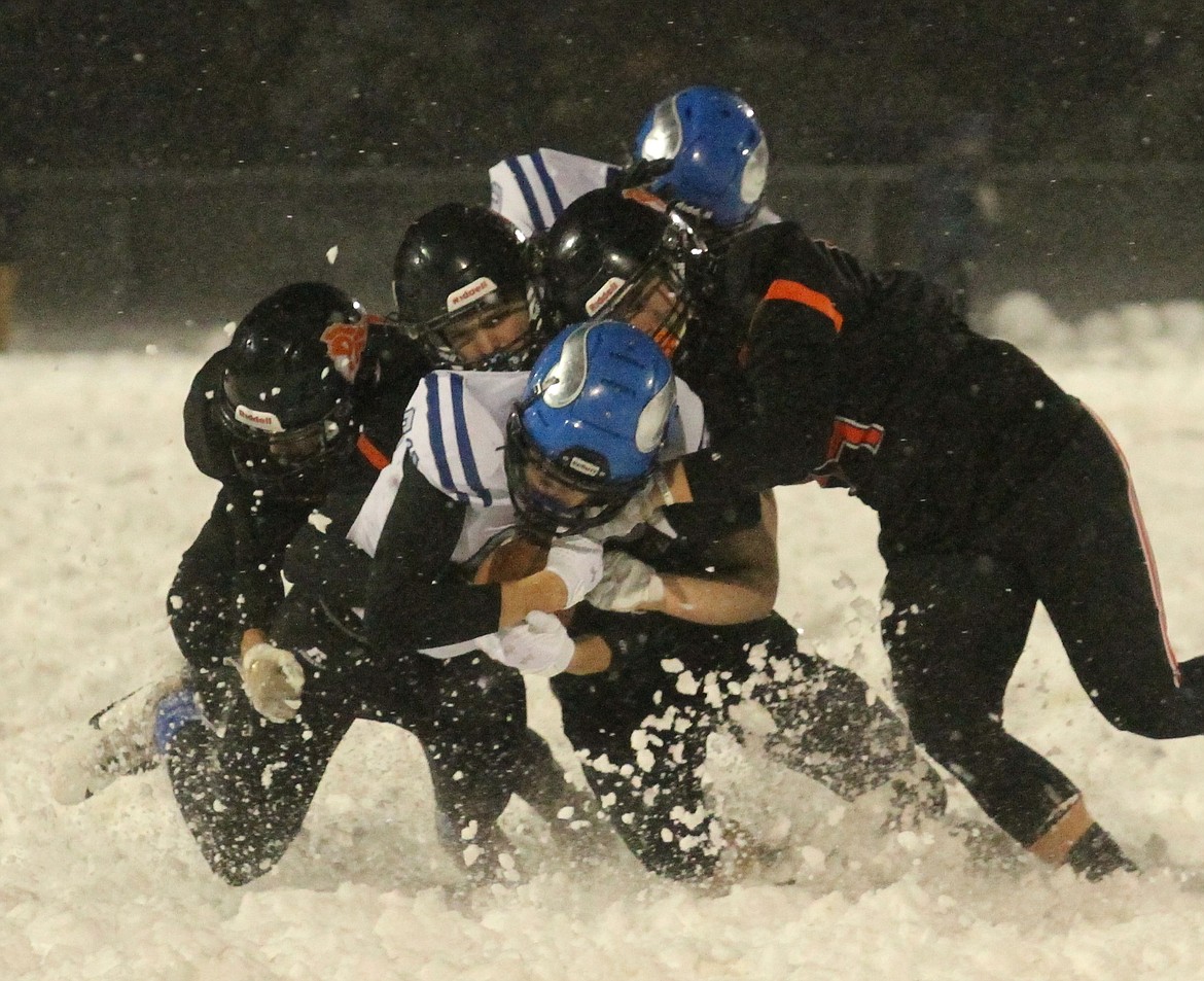 MARK NELKE/Press
It takes three Post Falls defenders to tackle Coeur d'Alene's Cameren Cope at the end of this pass reception Friday night.