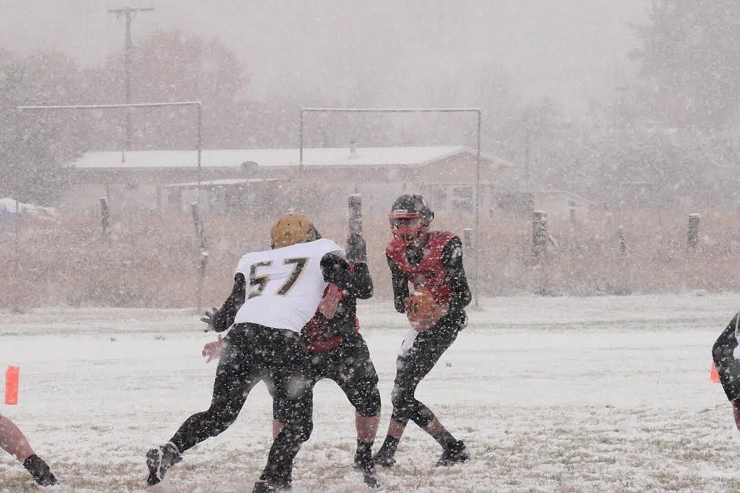 Plains QB Tristan Subatch with the ball looking through the snow for a receiver during Friday's game. Subatch ran for the only score in a 6-0 win to celebrate Senior Night. (Chuck Bandel/Valley Press)