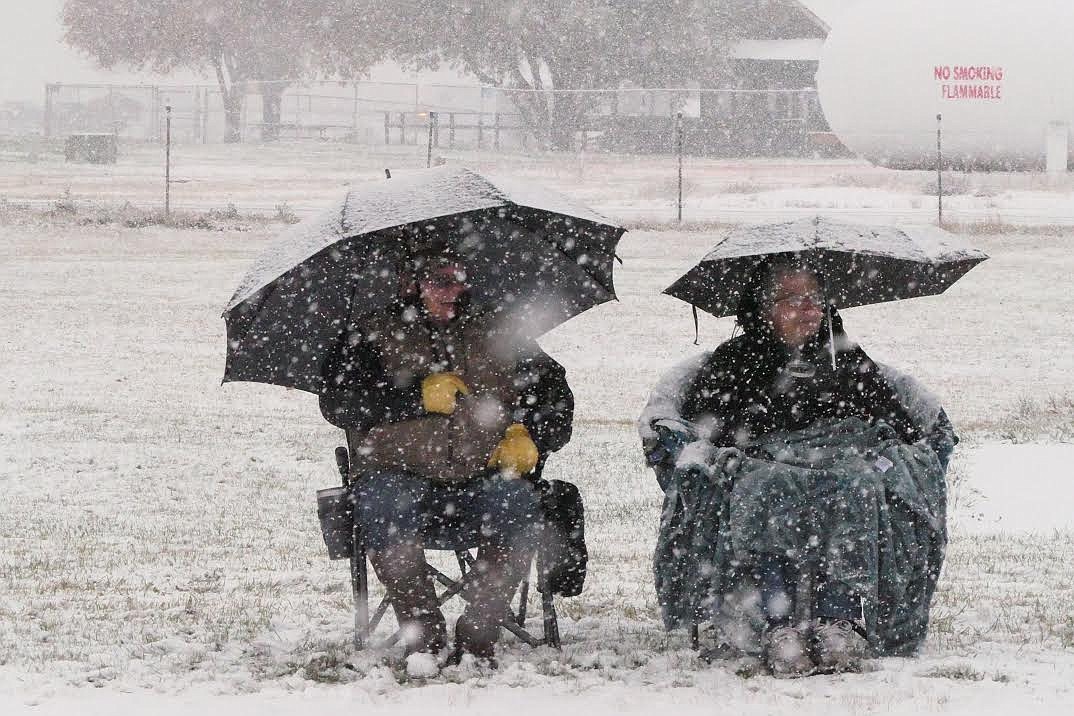 Two Plains football fans proved umbrellas are good to shield users from rain, sun and snow during Friday's game. The Horsemen beat Seeley-Swan, 6-0. (Chuck Bandel/Valley Press)