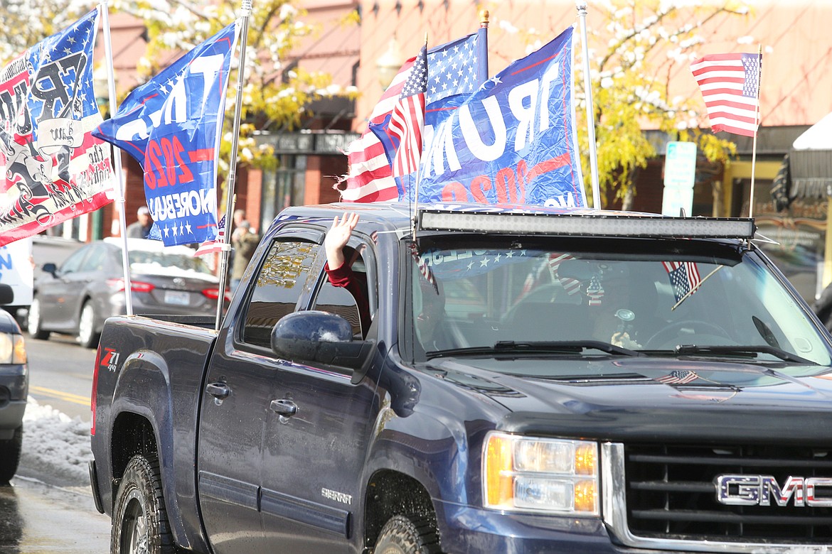 A passenger waves during the vehicle parade on Sherman Avenue to show support for President Donald Trump on Saturday.