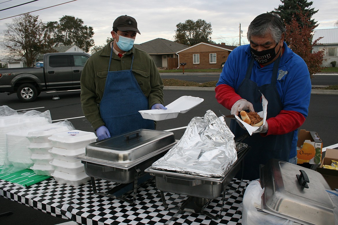 Jim Duzon of Top Gun Catering (right) and Micah Van Kirk (left) prepare a sandwich at the tailgate fundraiser for the Boy Scouts Monday in Moses Lake.