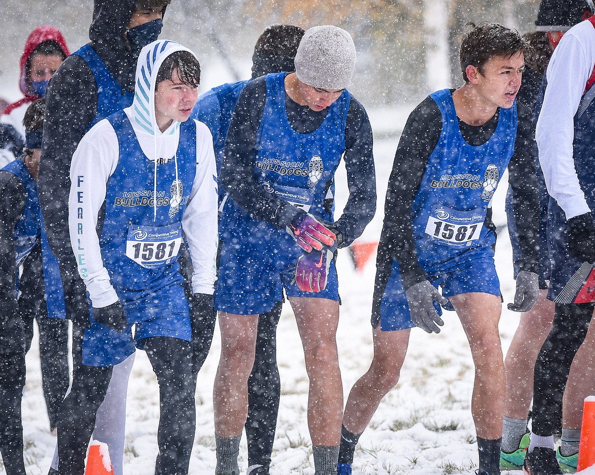 Mission runners Zoran LaFrombois (1581), Thomas Nuila (1585) and Andrew Rush (1587) await the start of the 2020 State B cross country meet in the swirling snow at Rebecca Farm in Kalispell. (Christa Umphrey, Forward Photography)