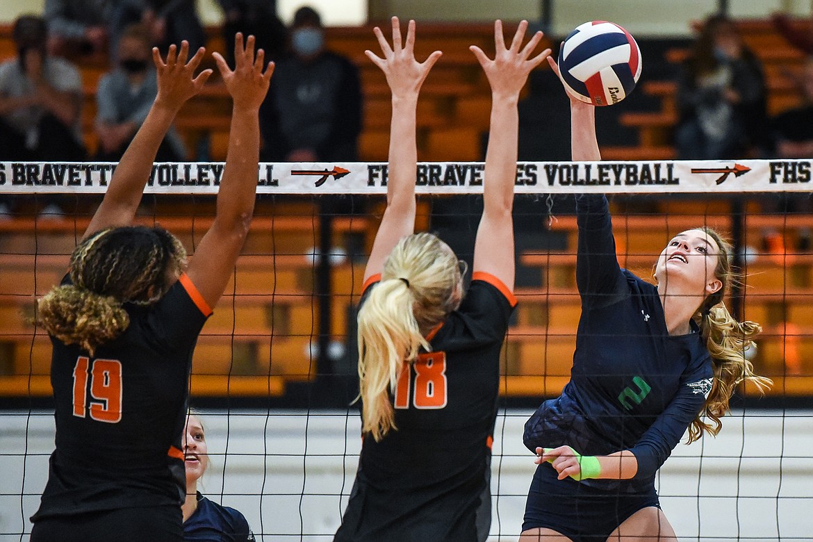 Glacier's Sidney Gulick (2) goes for a kill against Flathead's Akilah Kubi (19) and Madelyn Moy (18) during crosstown volleyball at Flathead High School on Tuesday. (Casey Kreider/Daily Inter Lake)