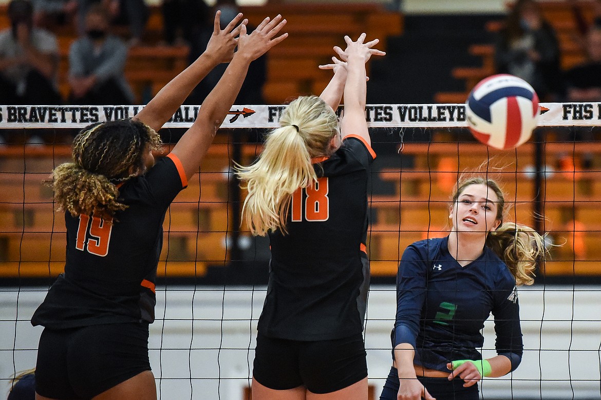 Glacier's Sidney Gulick (2) goes for a kill against Flathead's Akilah Kubi (19) and Madelyn Moy (18) during crosstown volleyball at Flathead High School on Tuesday. (Casey Kreider/Daily Inter Lake)