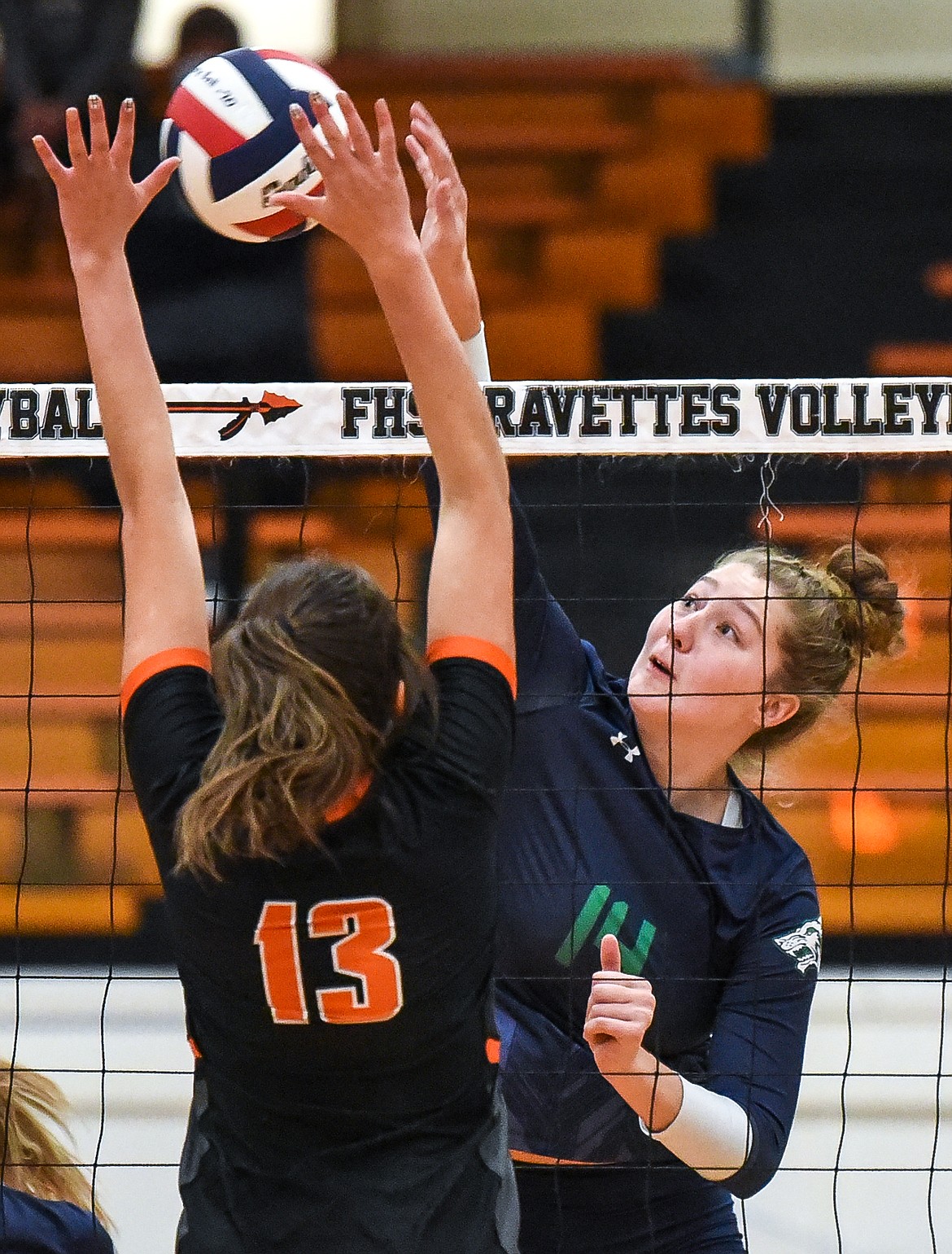 Glacier's Emma Anderson (14) goes for a kill over Flathead's Maddi Chavez (13) during crosstown volleyball at Flathead High School on Tuesday. (Casey Kreider/Daily Inter Lake)