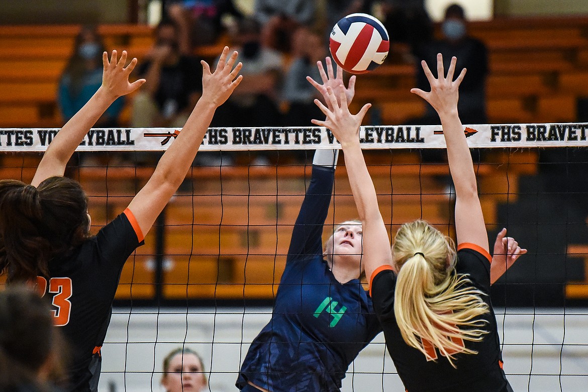 Glacier's Emma Anderson (14) goes for a kill against Flathead's Savanna Sterck (23) and Madelyn Moy (18) during crosstown volleyball at Flathead High School on Tuesday. (Casey Kreider/Daily Inter Lake)