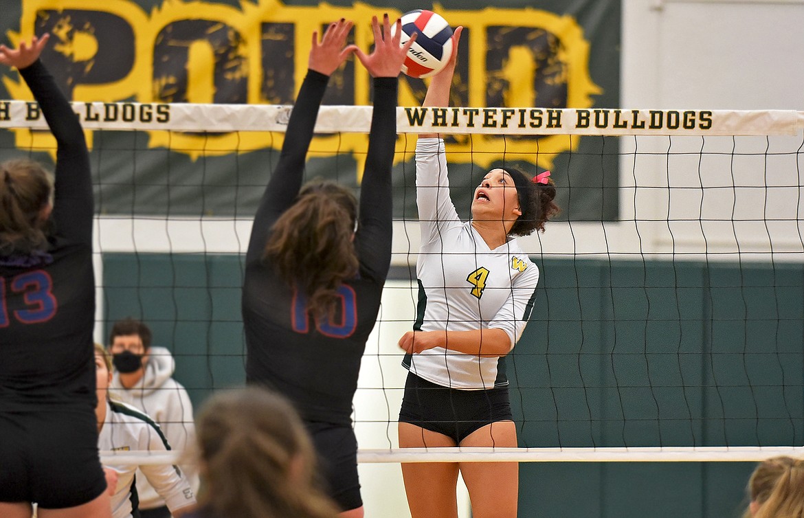 Whitefish's Emma Trieweiler rises above the net to spike the ball past Columbia Falls' Madeline Stutsman in a match on the Bulldog's home court Thursday evening. (Whitney England/Whitefish Pilot)