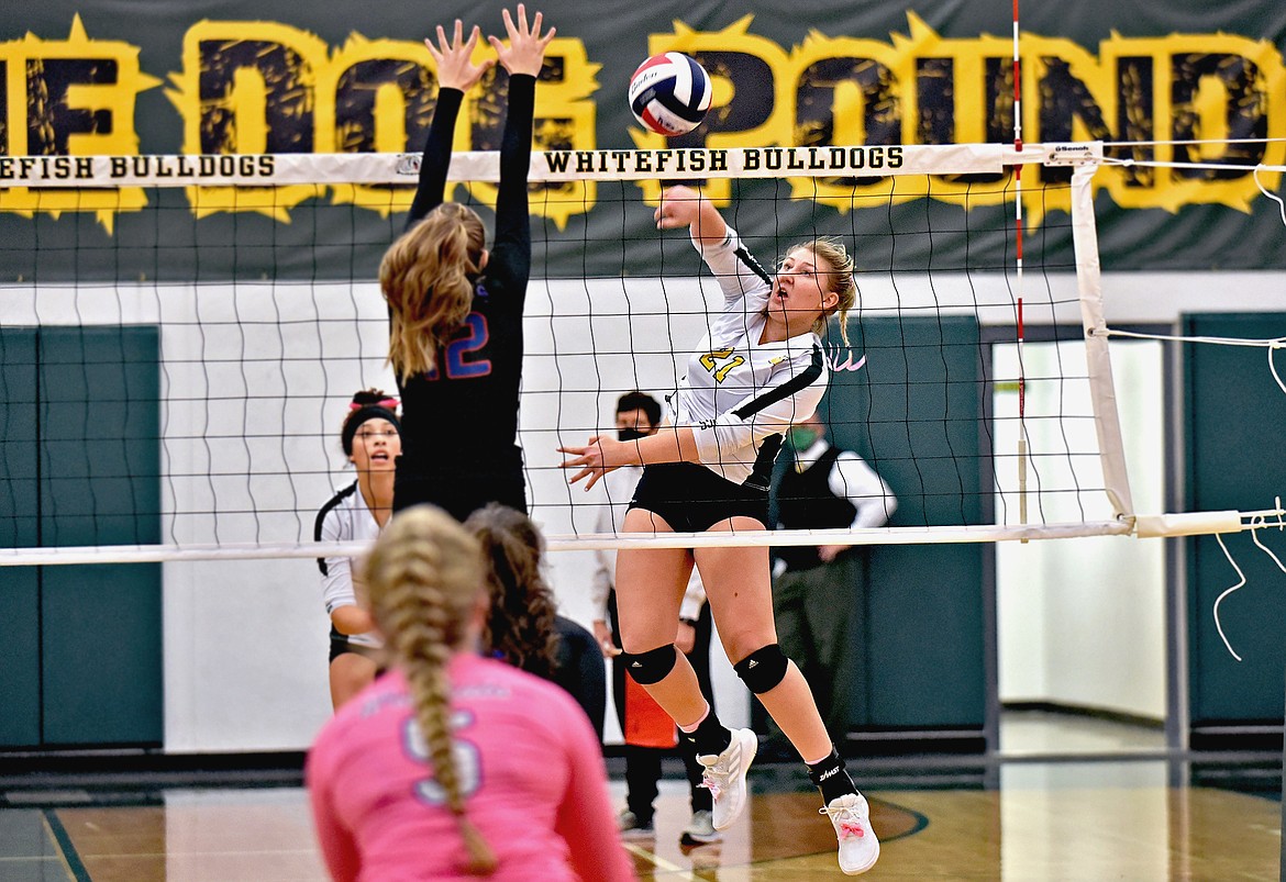Lady Bulldog Brook Smith strikes the ball powerfully past a Columbia Falls blocker during a match in Whitefish Thursday evening. Smith led her team with eight kills. (Whitney England/Whitefish Pilot)