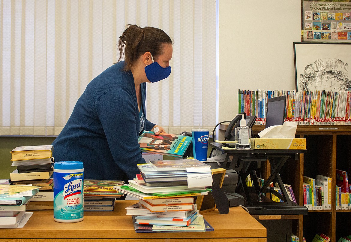 Carriann Gray, Children's Library Associate with Moses Lake Public Library, gets some books checked in as things get set up for reopening on Wednesday afternoon.