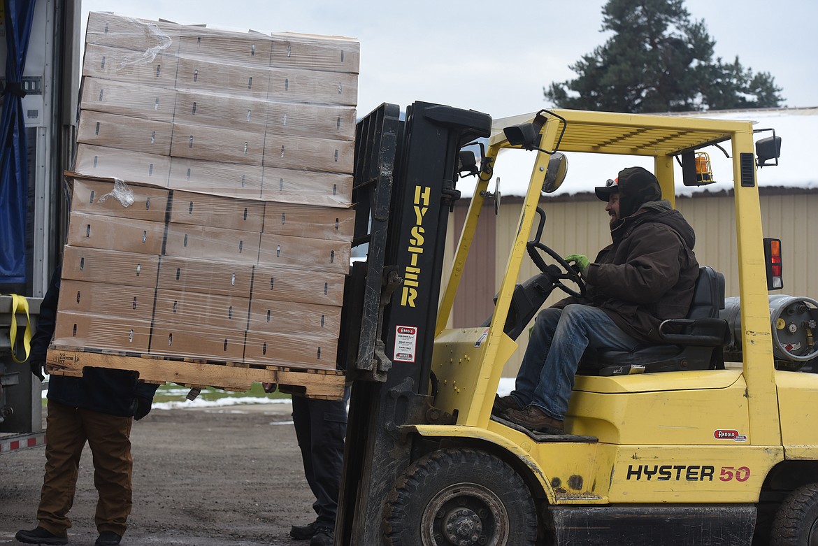 Volunteer TJ Thomas unloads pallets of food boxes from a delivery truck during an Oct. 28 Lincoln County Food Box Distribution event.