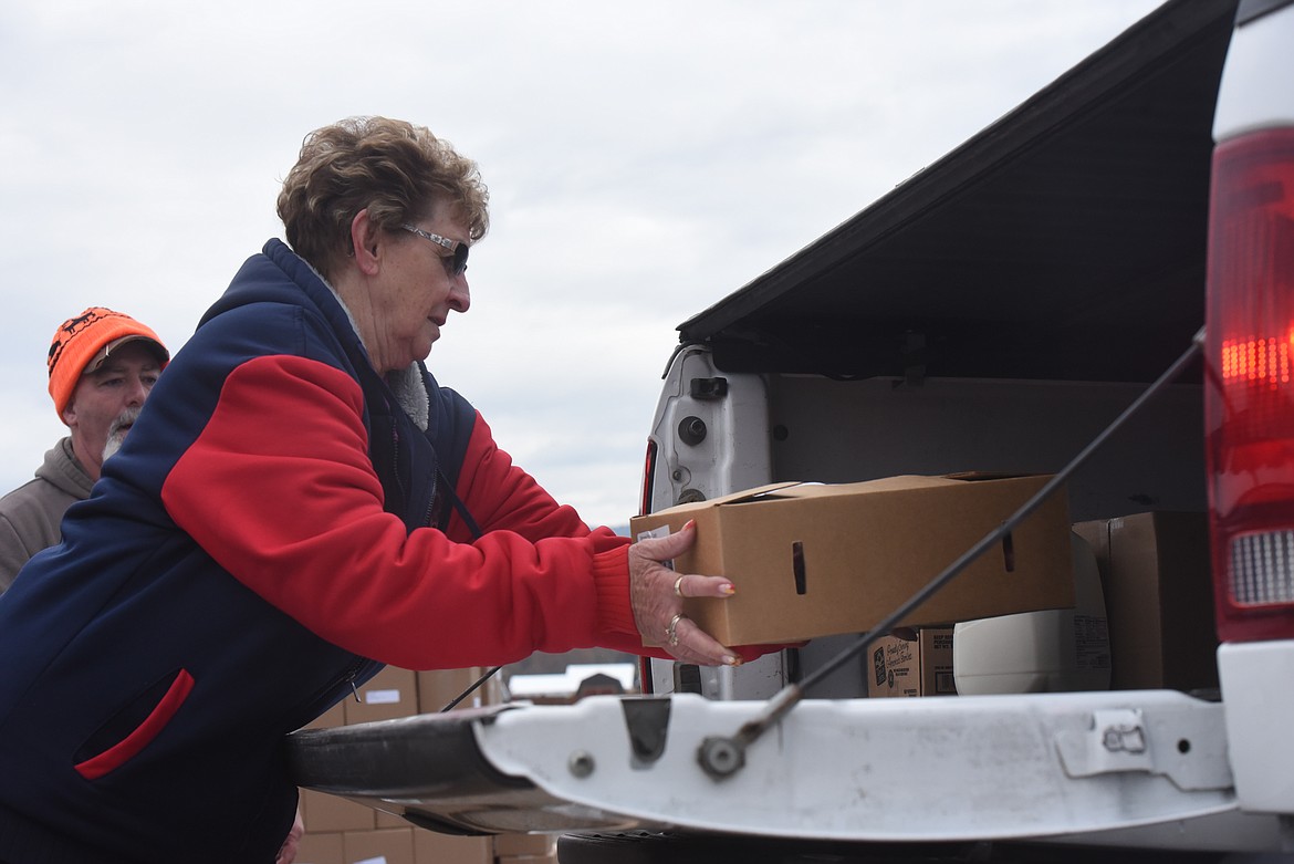 Volunteer Rose Howard loads boxes into the back of a pickup during an Oct. 28 Lincoln County Food Box Distribution event.