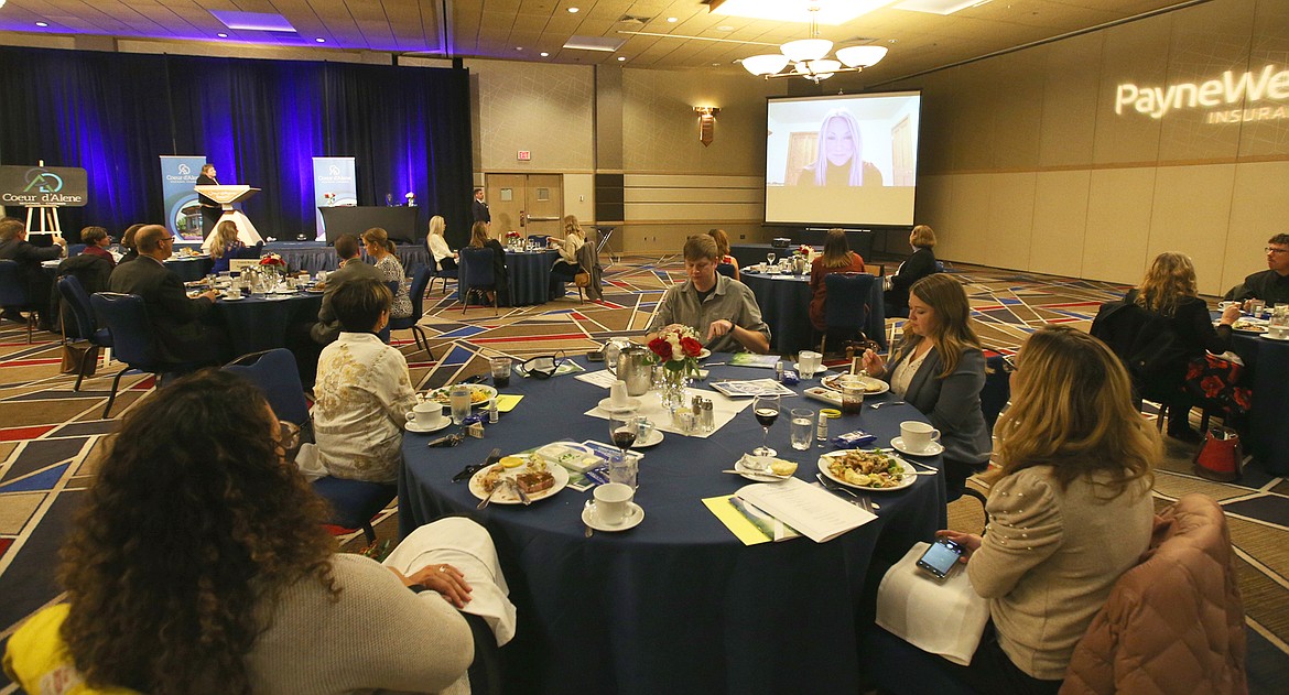 Ann Thomas, incoming chair of the Coeur d'Alene Regional Chamber, addresses the crowd via Zoom during the chamber's annual meeting Thursday at The Coeur d'Alene Resort, while current chair Heidi Rogers listens at the podium.
