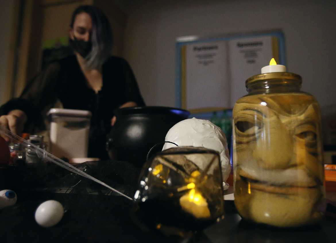 Girl Scout leader Courtney Crookham prepares festive goodies for her troop on Wednesday evening during a spooky science party in the Silver Lake Mall. The girls made potions, slime, static electric ghosts and enjoyed a Halloween dance party.