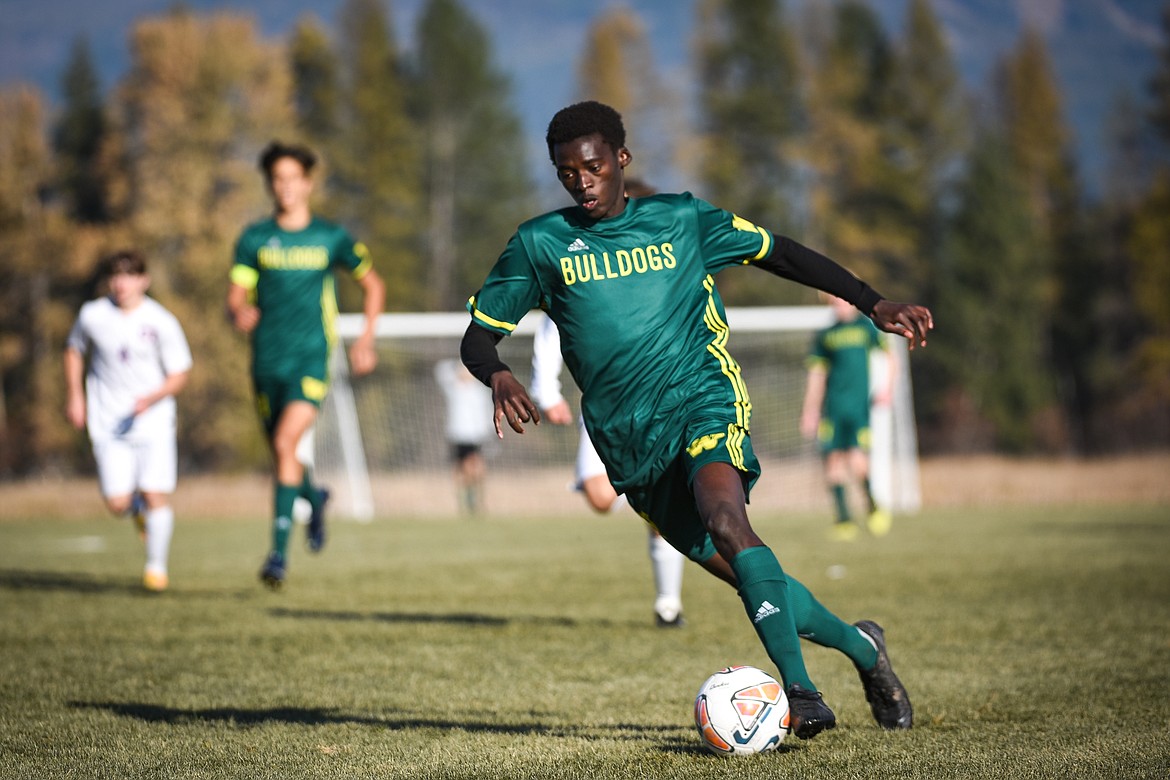 Whitefish's Marvin Kimera (22) pushes the ball upfield against Columbia Falls in the first half during the Class A boys soccer championship at Smith Fields in Whitefish on Saturday. (Casey Kreider/Daily Inter