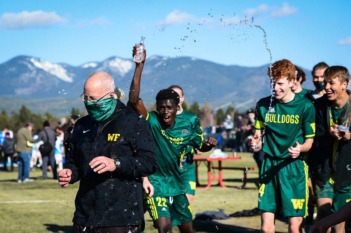 Whitefish players soak head coach John Lacey after their 3-0 win over Columbia Falls in the Class A boys soccer championship at Smith Fields in Whitefish on Saturday. (Casey Kreider/Daily Inter Lake)