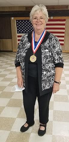 Sanders County Coalition for Families volunteer Judy Stephens shows off her gold medal she was awarded from the President’s Volunteer Service. (Chuck Bandel/Valley Press)