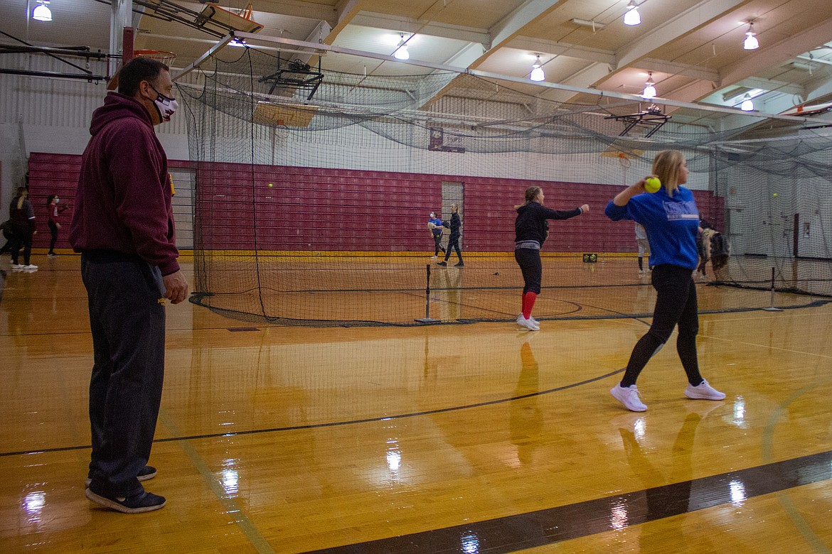 MLHS head softball coach Michael Hofheins watches on as his players warm up with some throwing inside the gym on Tuesday afternoon.