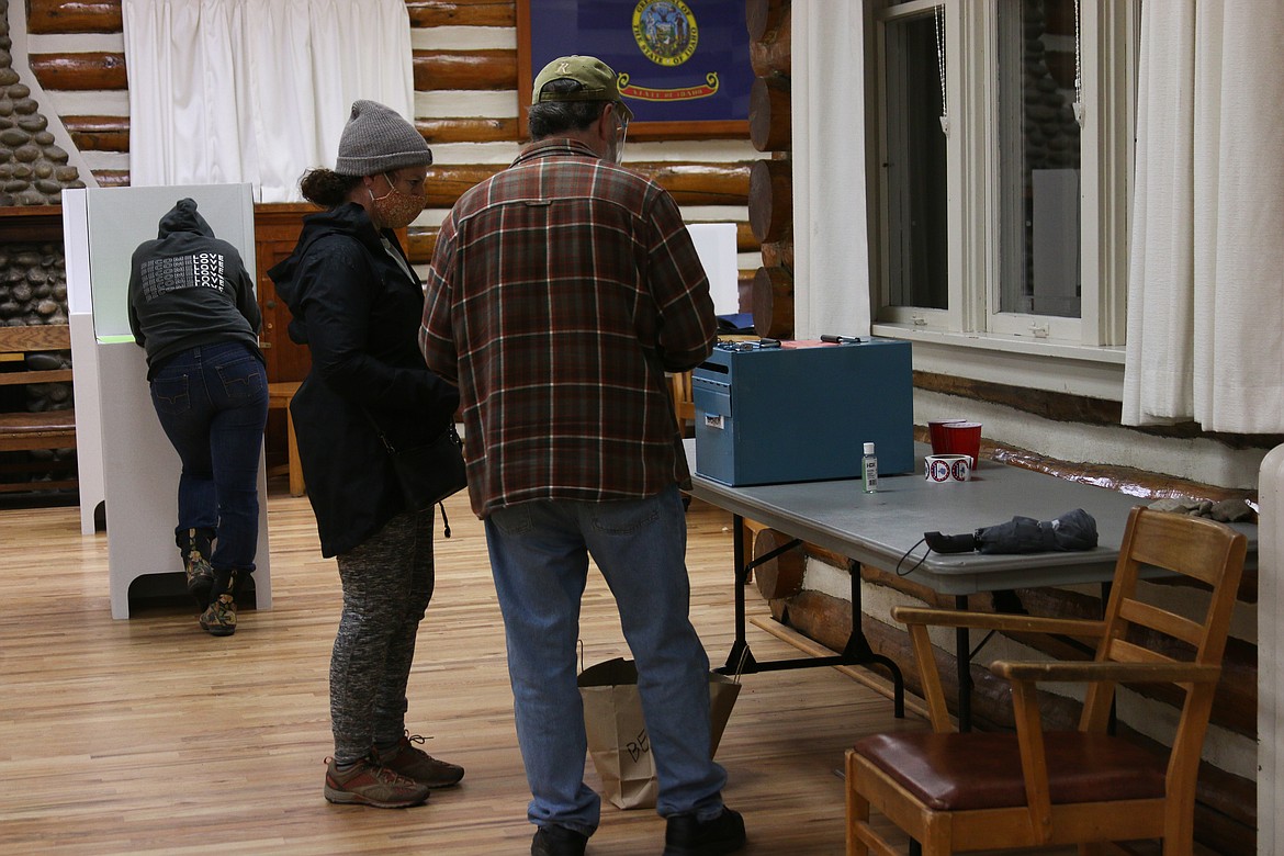 Poll worker Rob Manly talks to Gina Piazzola as she casts her ballot Tuesday night.