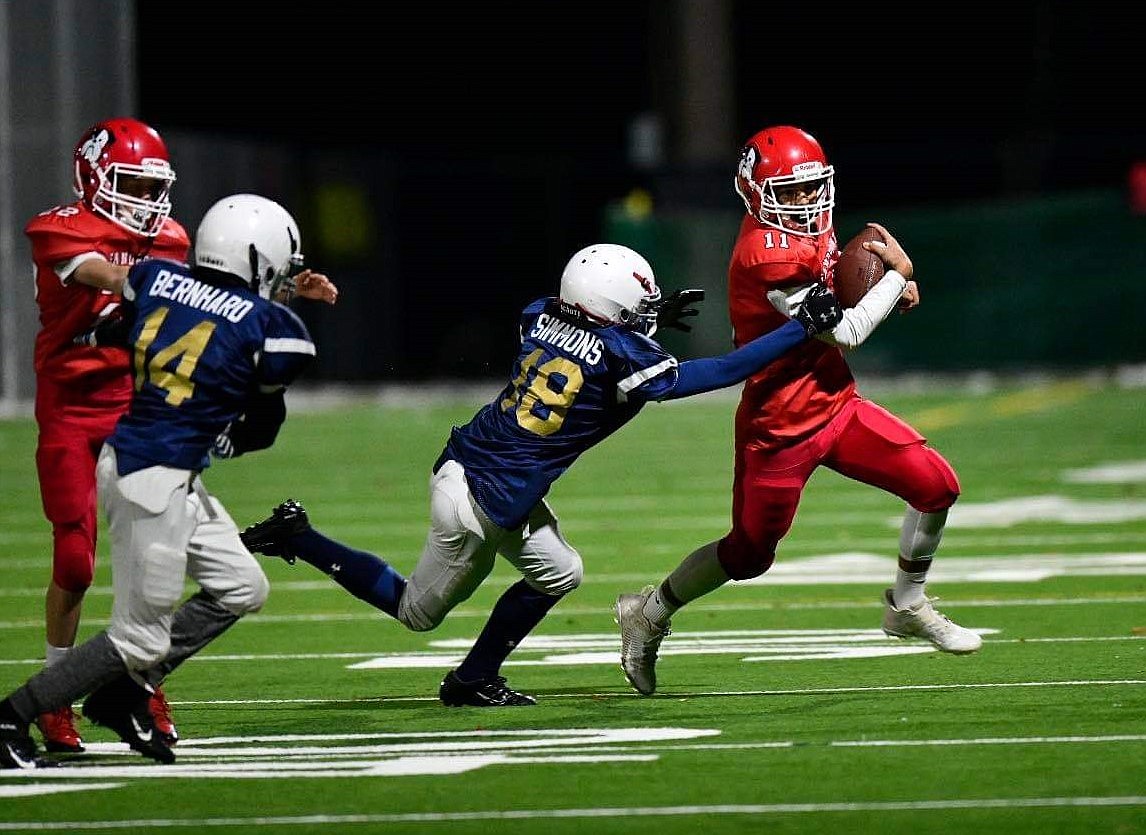 Quarterback Andrew Lehman (far right) cuts through the Timberlake defense during a game on Oct. 27 at War Memorial Field.