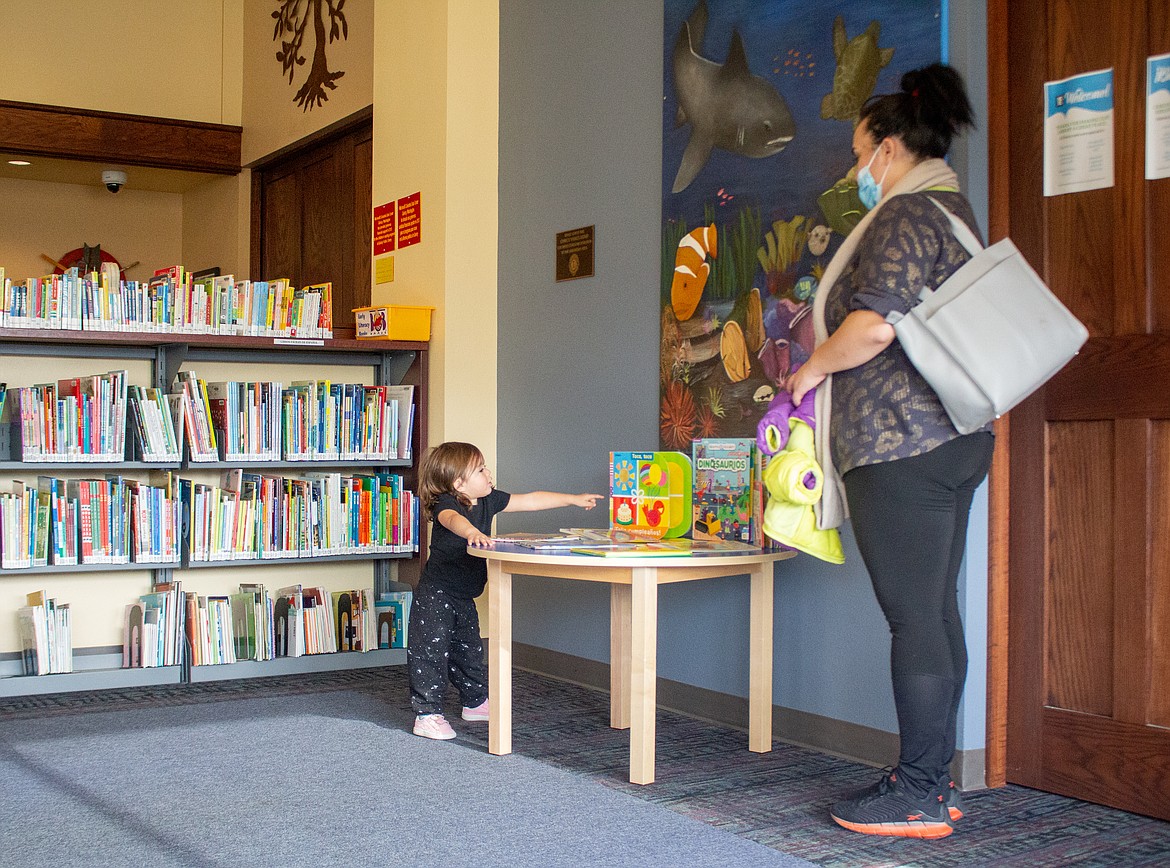 Galilee Onitveros points to a book on the table at the Quincy Public Library on Wednesday as her mother, Christine Ontiveros, watches on.