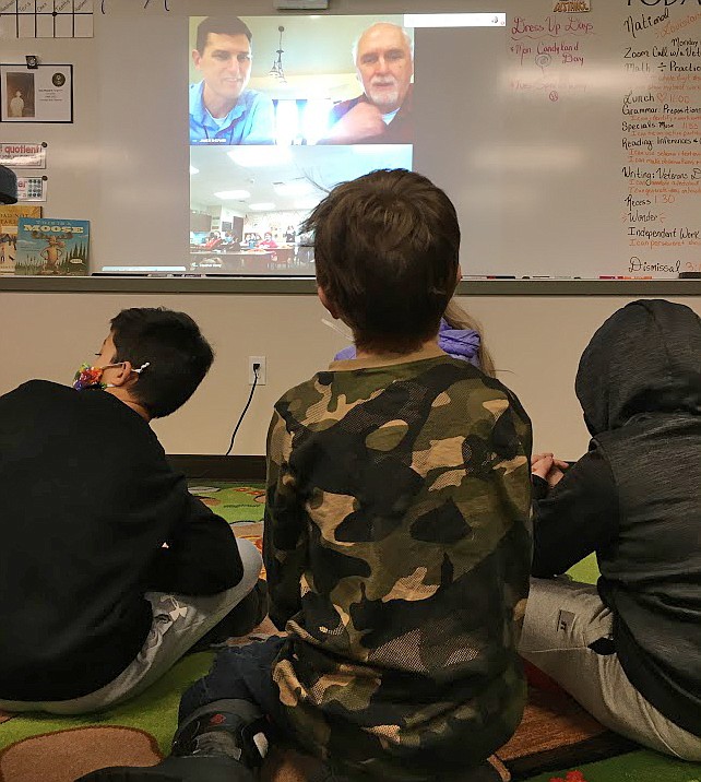 A class of fifth-graders at Treaty Rock Elementary during a Veterans Day event this week engage with teacher James Shepard, left, and his dad, Don Shepard, about Don's experiences in the Army.