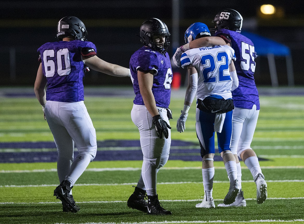 DARIN OSWALD/The Idaho Statesman
Coeur d'Alene's Ty Pottenger (22) is consoled by Zack Black (55) and Zachary Nyland (60) of Rocky Mountain after Friday night's state 5A semifinal, won by Rocky 36-21. Also pictured is Justin Kozlowski of Rocky Mountain.