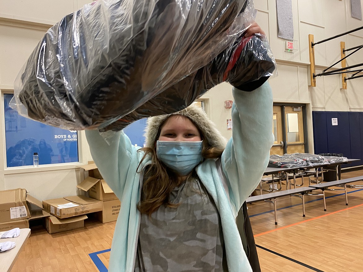 Lexi McDaniel, 9, is super stoked about her new jacket from the Clothes4Souls and Macy's "Sharing the Warmth" giveaway she got at the Lola and Duane Hagadone Club Friday Night. (MADISON HARDY/Press)