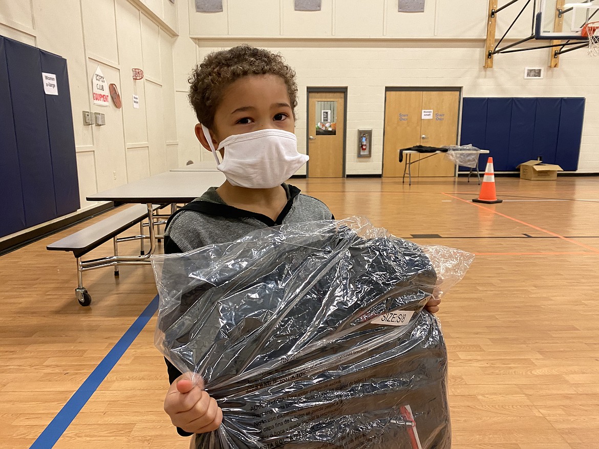 Wesley Fields, 6, likes his new red, black, and grey jacket he got from the Macy's and Clothes4Souls "Sharing the Warmth" coat giveaway with the Lola and Duane Hagadone Boys & Girls Club because it is not too puffy. (MADISON HARDY/Press)