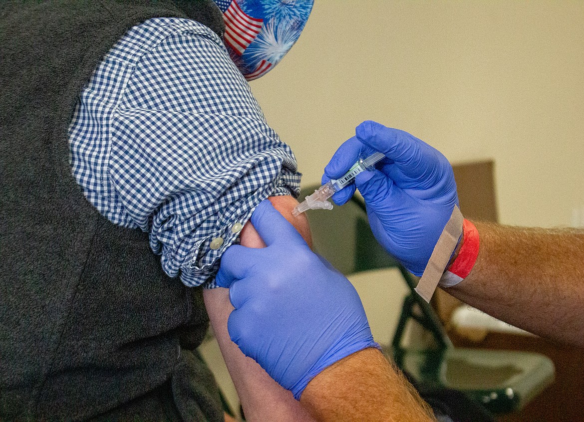 Lloyd Stever, a volunteer and Pharmacy Director at Samaritan Hospital, gives Milton Miller, left, his flu shot at the Free Flu Shot Clinic at Samaritan Clinic on Patton on Friday afternoon in Moses Lake.