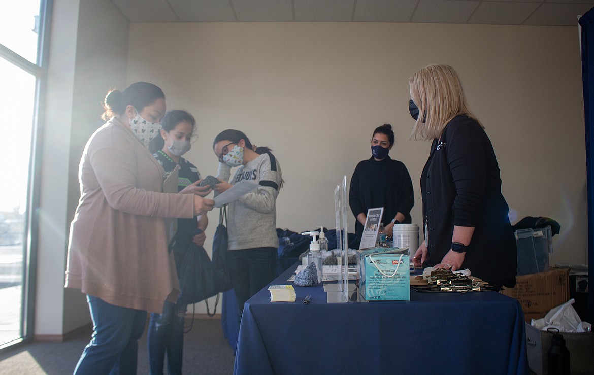 Left to right,Beatriz Lucio and her two daughters, Breanna and Natalie, check in with Misty Aguilar at the Free Flu Shot Clinic on Friday afternoon on Patton Boulevard in Moses Lake.