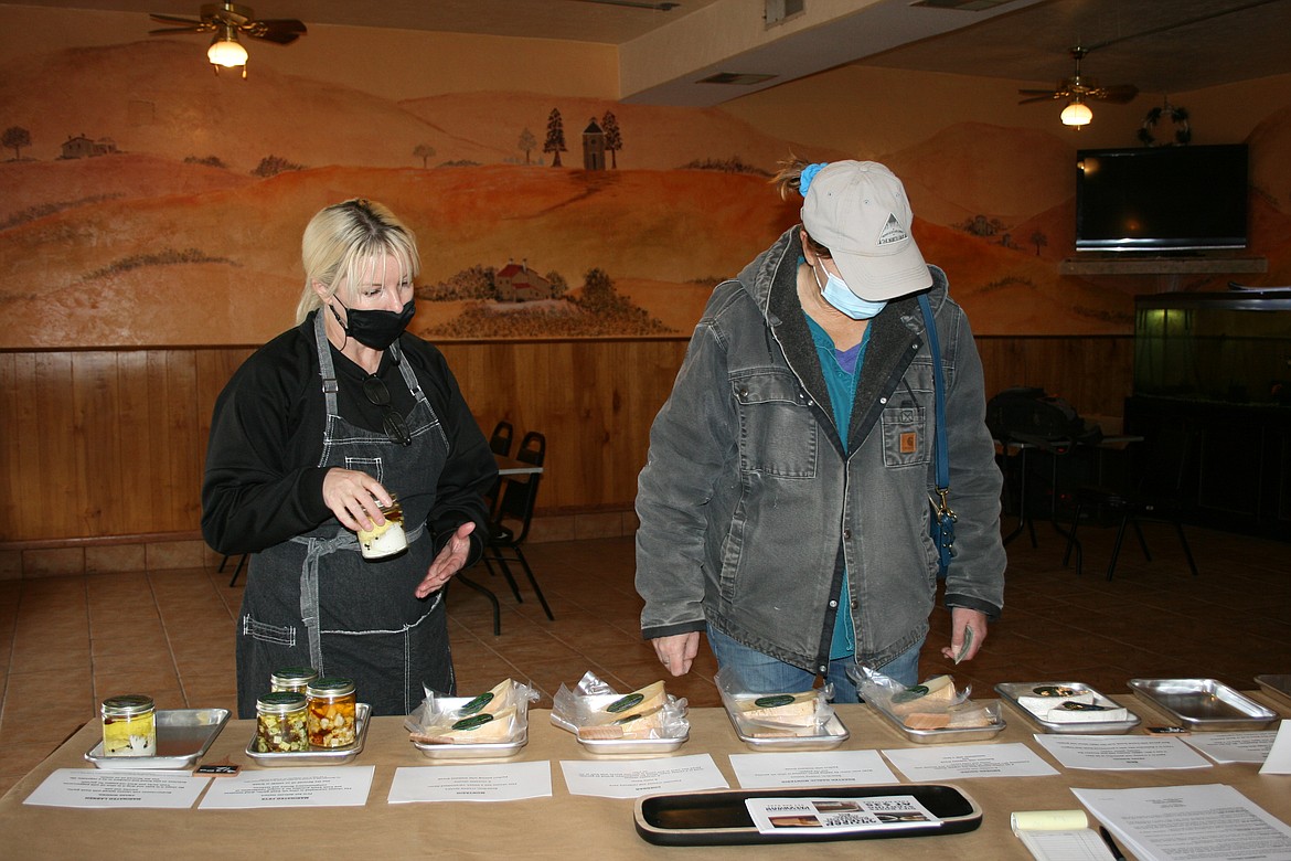 Jennifer Baginski (left) helps customer Kyya Grant (ight) make her selection among cheeses offered by the Cow Path Artisan Bakery and Creamery at their pop-up location in Othello.