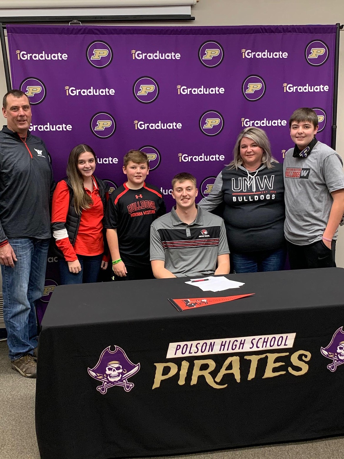 Polson High School senior Trevor Lake signed a letter of intent to play football with the UM-Western Bulldogs at Dillon. Pictured, left to right, are Tim Lake, Madison Lake, Ryan Lake, Trevor Lake, Chanel Lake, Chris Lake and Pirates head coach Kaden Glinsmann. (courtesy of Betsy Wade)