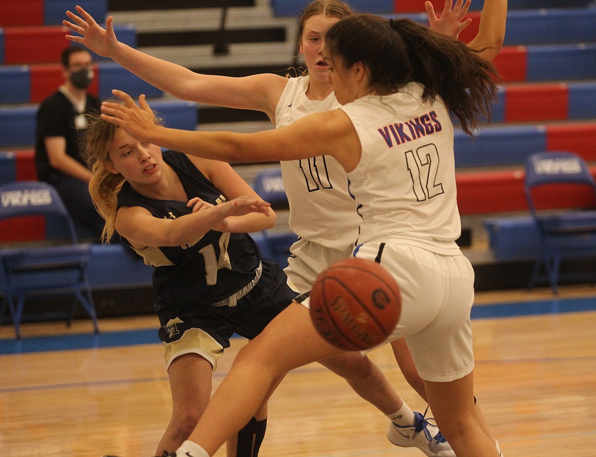 MARK NELKE/Press
Parker Wall of Timberlake passes around the defense of Madi Symons (11) and Jayda Johnson (12) of Coeur d'Alene on Tuesday night at Coeur d'Alene High.