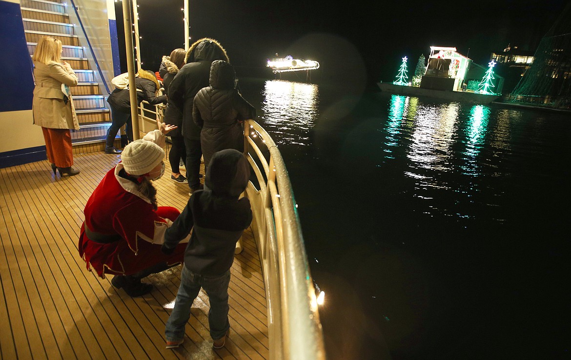 Jingle the elf talks with a child at Santa's workshop after they reached the North Pole during a boat cruise across Lake Coeur d'Alene Tuesday night.