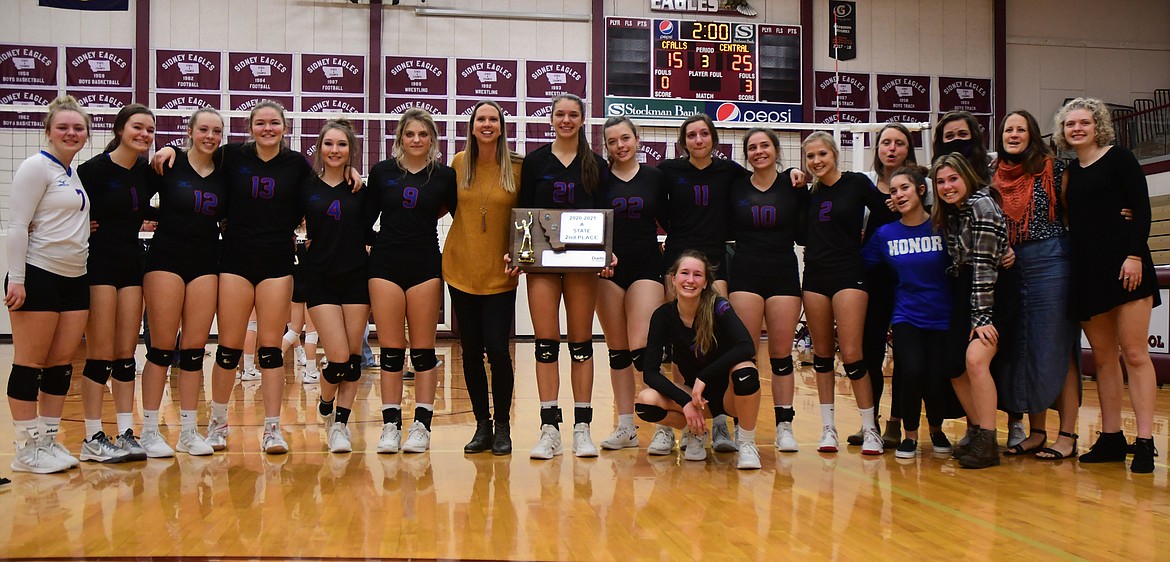 The Wildkat volleyball team poses with their second place State A trophy after the championship match in Sidney on Saturday. Back row, left to right: McKenna Rensel, Rhys Sharpton, Lauren Falkner, Grace Gedlaman, Isabel Brandeberry, Hannah Schweikert, head coach Jolandie Brooks, Mady Hoerner, Maddy Collins, Jazzy Marino, Madeline Stutsman, Haylee Lawrence, coach Anna Danley, coach Haley Belgarde, coach Gretchen Miller, Demye Rensel. Front row, left to right: Dillen Hoerner, Jayden Webb, Aspen Dawson.  
(Teresa Byrd/Hungry Horse News)