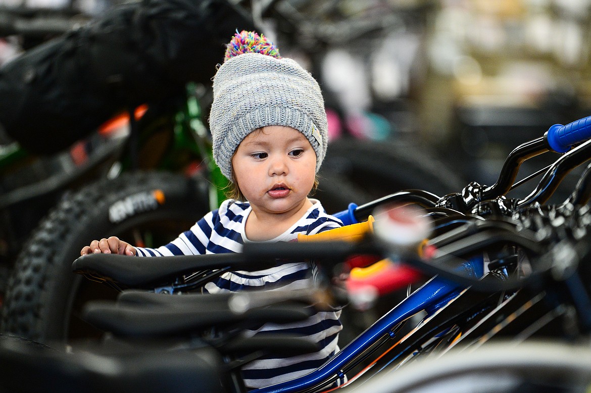 Twenty-month-old Naddie Landry checks out a selection of kids bikes with her father Drew Landry, of East Glacier, at Wheaton's Cycle in Kalispell on Wednesday, Oct. 18. (Casey Kreider/Daily Inter Lake)