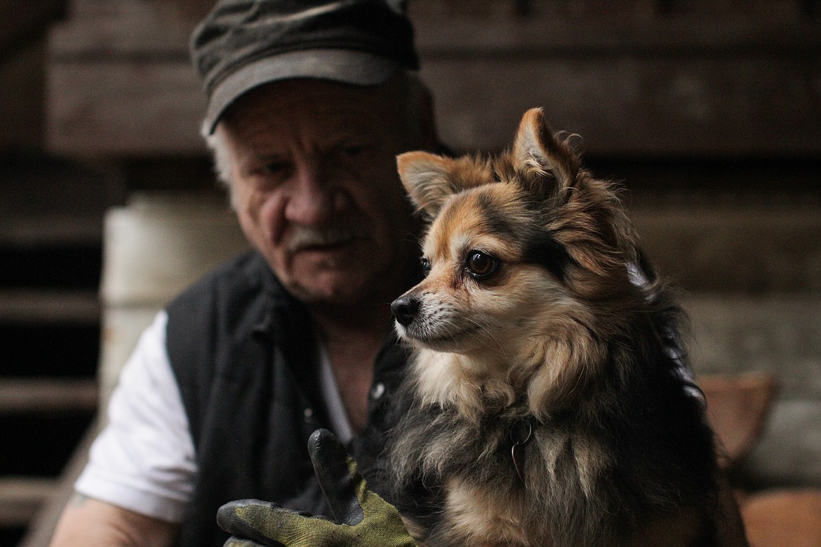 Frank Holbrook holds Jasmyn, one of his three dogs, Tuesday afternoon in Clark Fork.