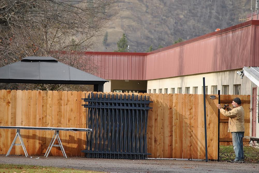 Michael Blyzek installs a metal post for a section of iron fence panels to be put in place at the new outdoor visitor space for Mineral Community Hospital. Although project completion won't be until next spring, the fencing was expected to be finished up last week. (Amy Quinlivan/Mineral Independent)